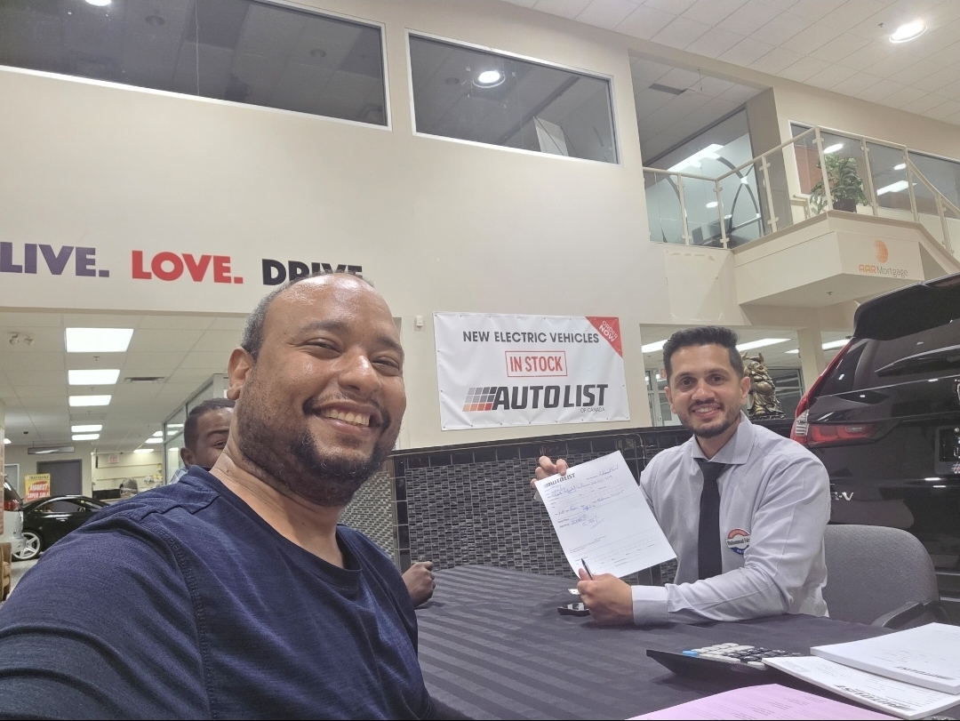 Dr. Ahmed finalising paperwork with Muhammad Faisal inside the Auto List of Canada showroom, Winnipeg